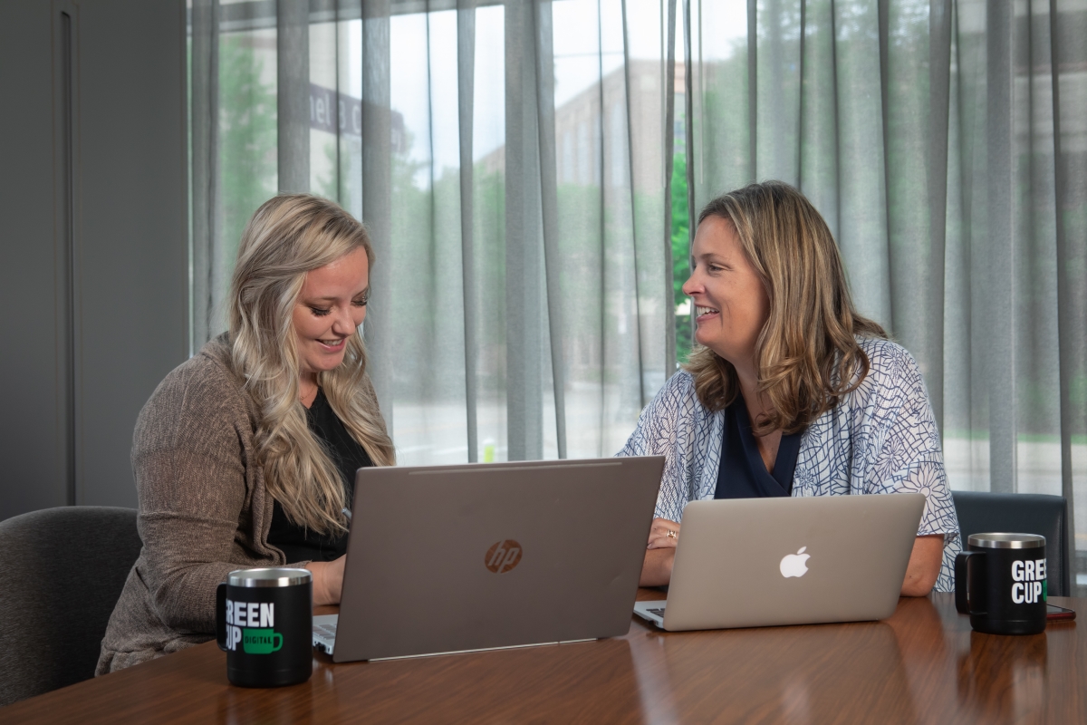 Kendra and Anne of GreenCup Digital reviewing a client's digital marketing needs
